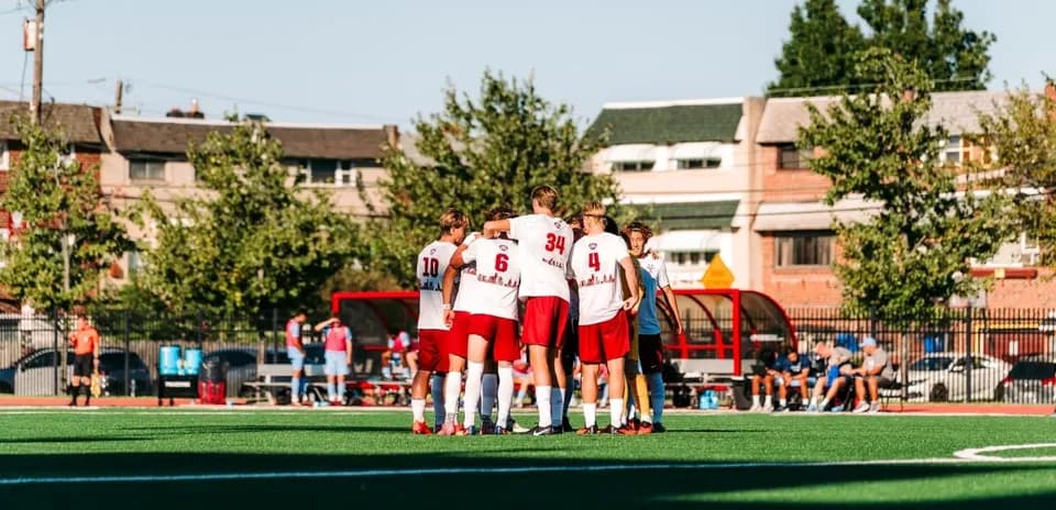 Team huddling together on soccer field before match