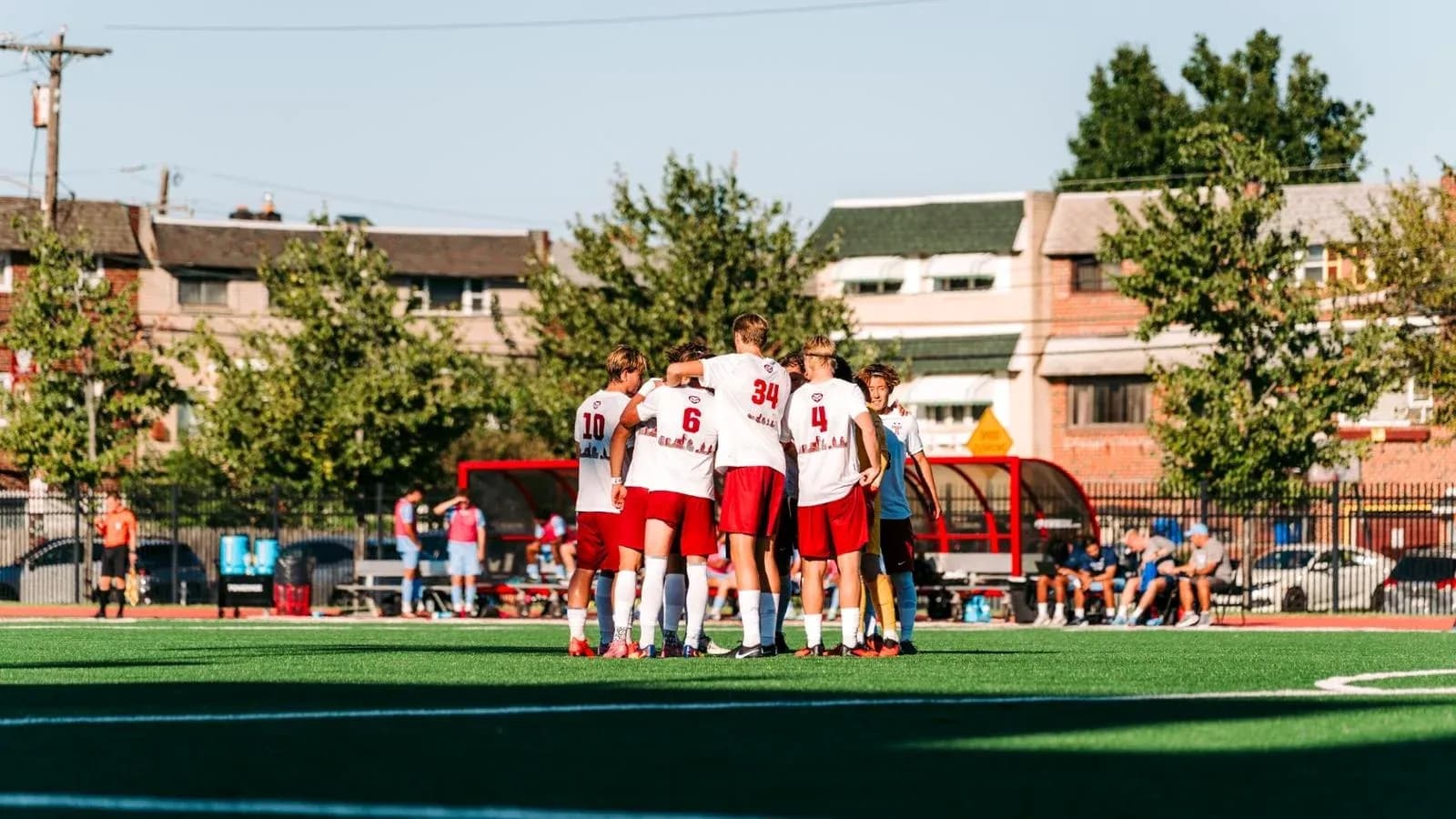 Team huddling together on soccer field before match