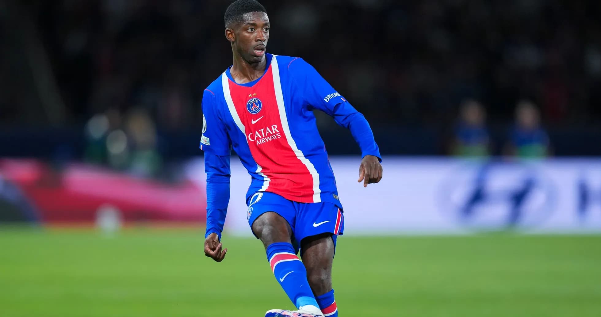 Player in PSG jersey dribbling during match