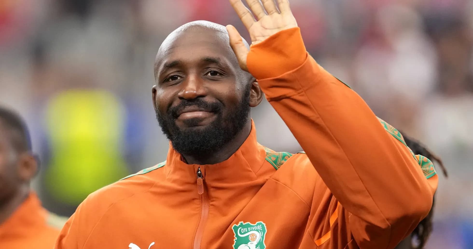 Player waving while wearing Cote d'Ivoire tracksuit
