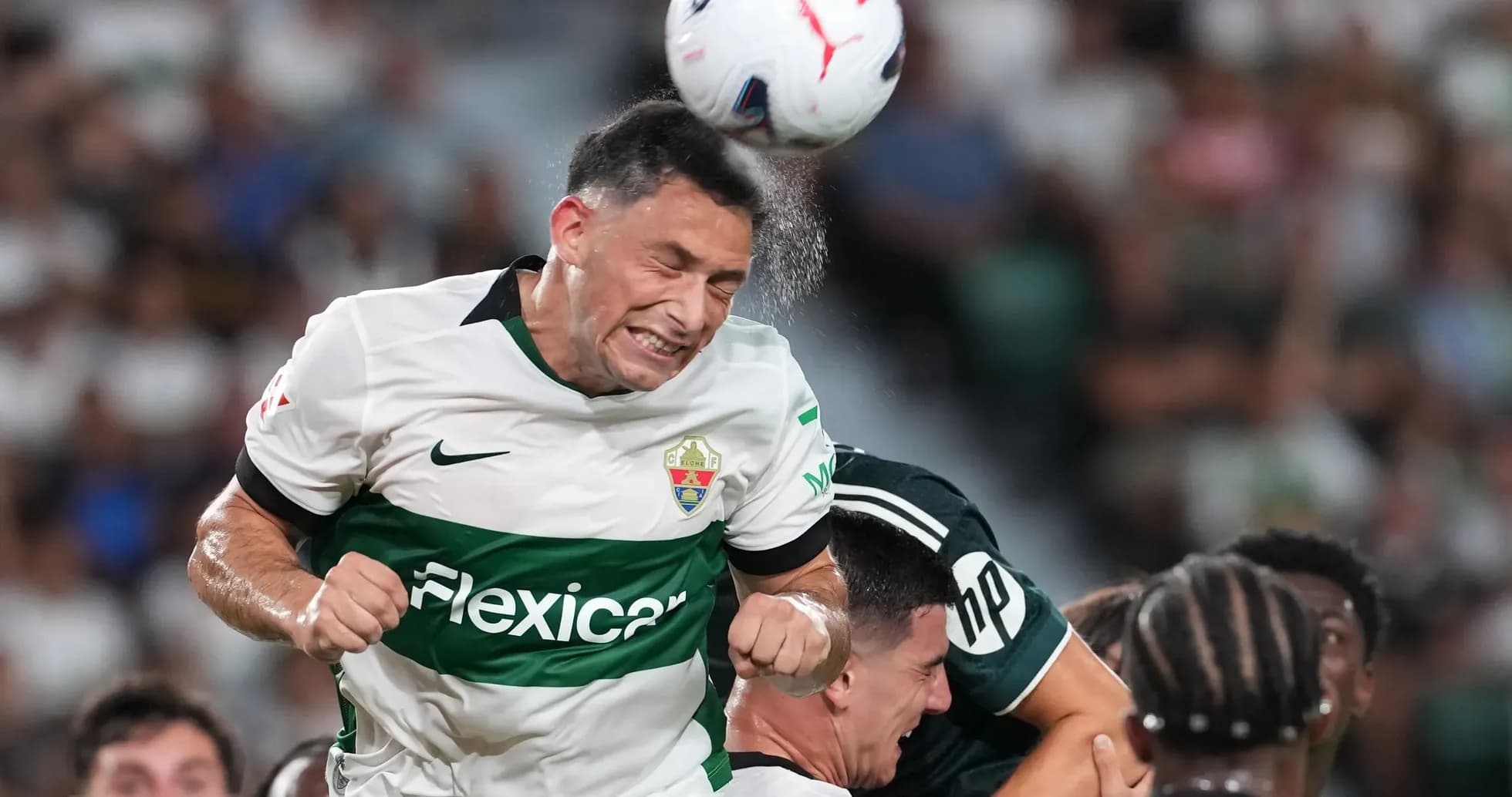 Elche player heading the ball during match