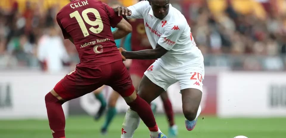 Celik and player contesting for the ball