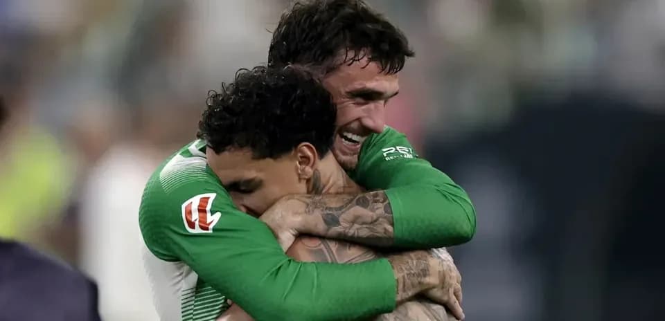Two players celebrating with a hug after match