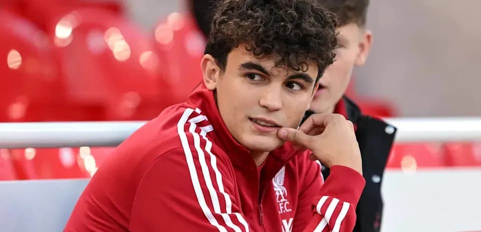 Player in Liverpool FC jacket sitting on bench