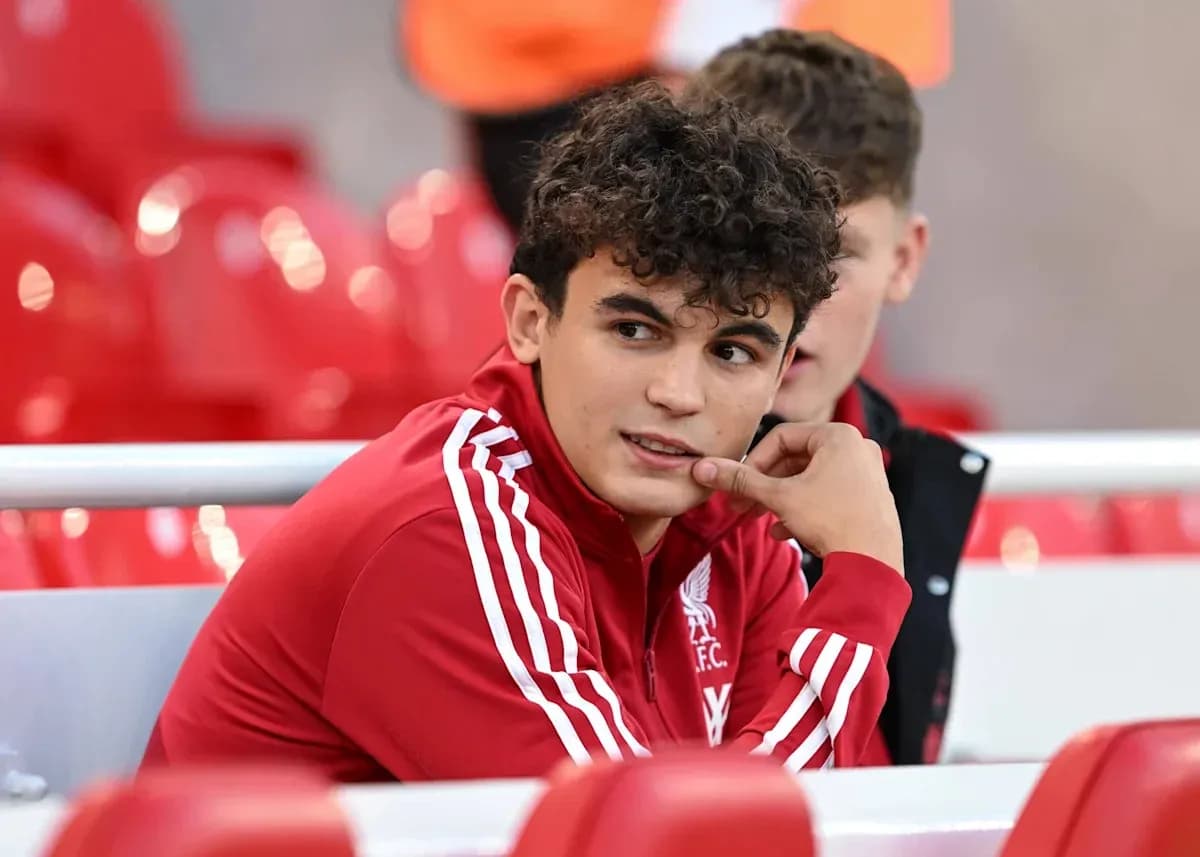 Player in Liverpool FC jacket sitting on bench