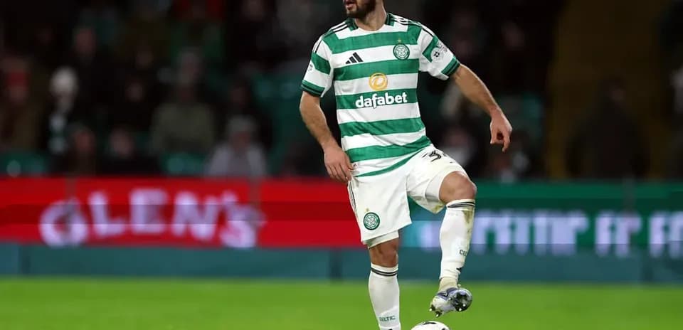 Player in Celtic kit controlling the ball on pitch