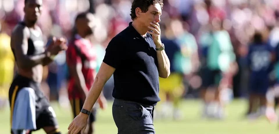 Coach walking off the pitch after match conclusion