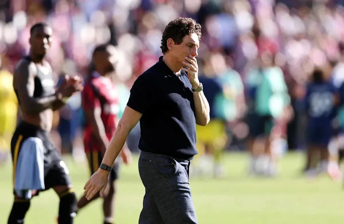 Coach walking off the pitch after match conclusion
