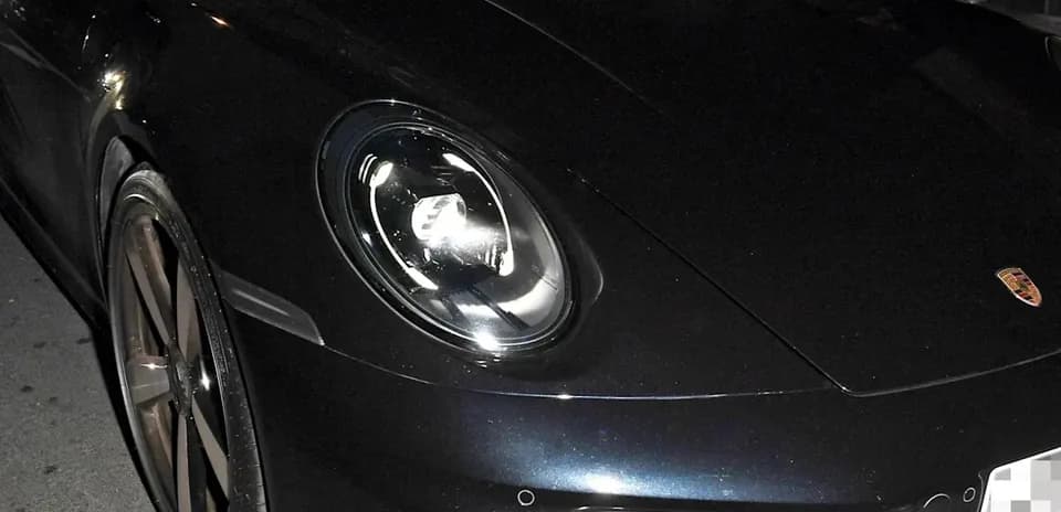 Two men in a Porsche parked at night