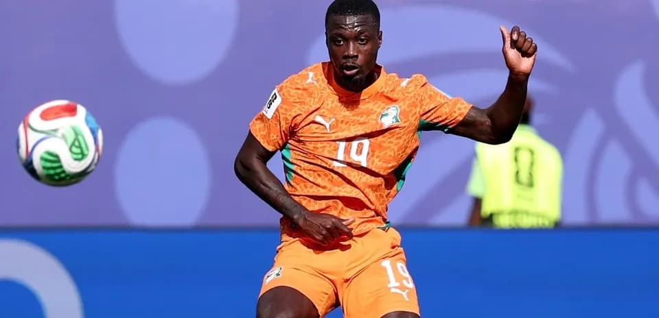 Player in orange kit controlling the soccer ball
