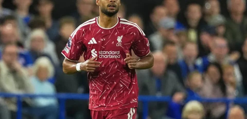 Liverpool player running during match with fans in background