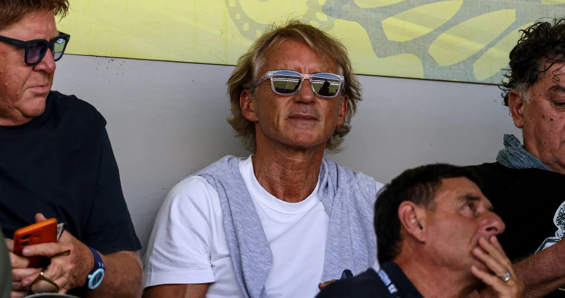 Man with sunglasses sitting among spectators