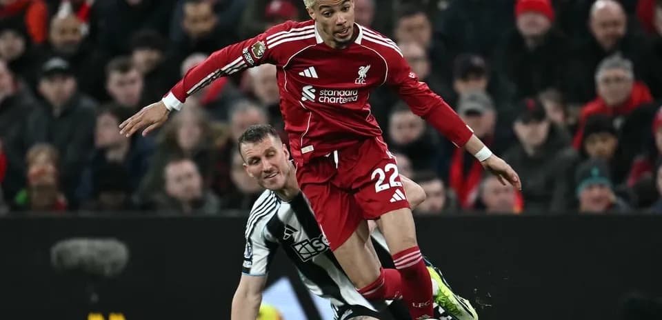 Liverpool player challenging Newcastle opponent during match