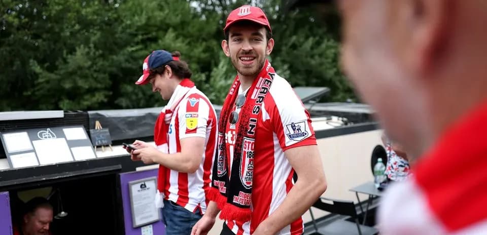Fans wearing team jerseys and scarves at event