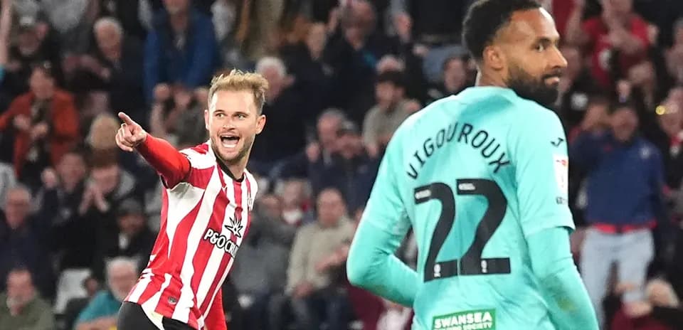 Player celebrating a goal with teammate in match
