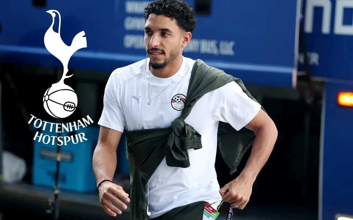 Player walking with jacket draped during arrival