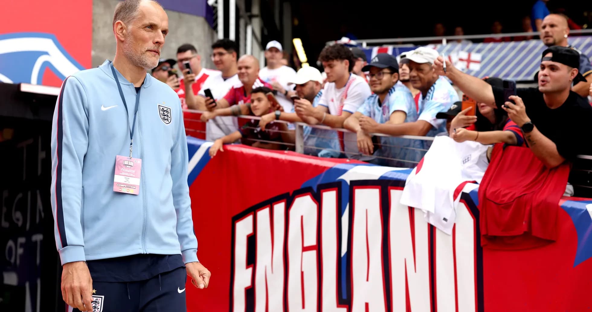 Coach walking past fans before the match