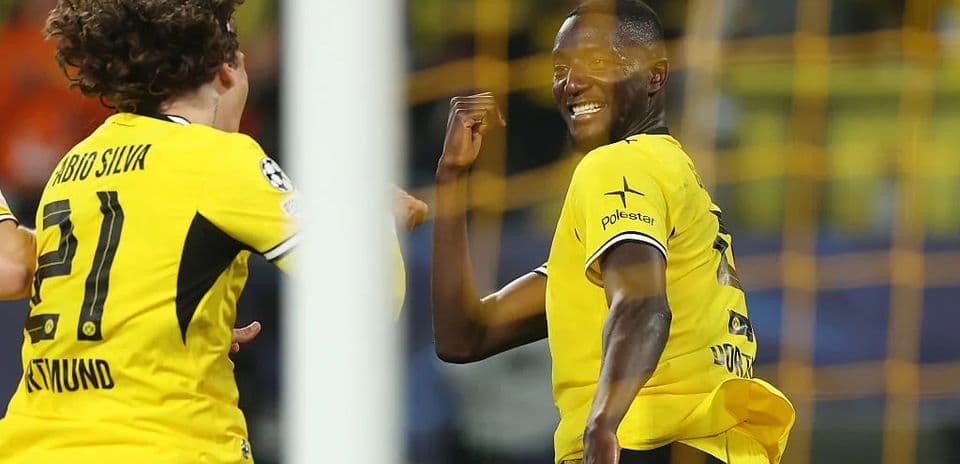 Two players celebrating a goal in yellow jerseys