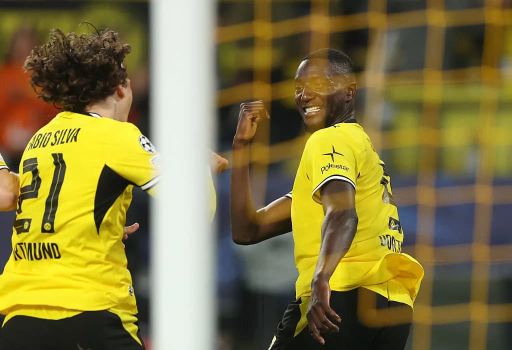 Two players celebrating a goal in yellow jerseys