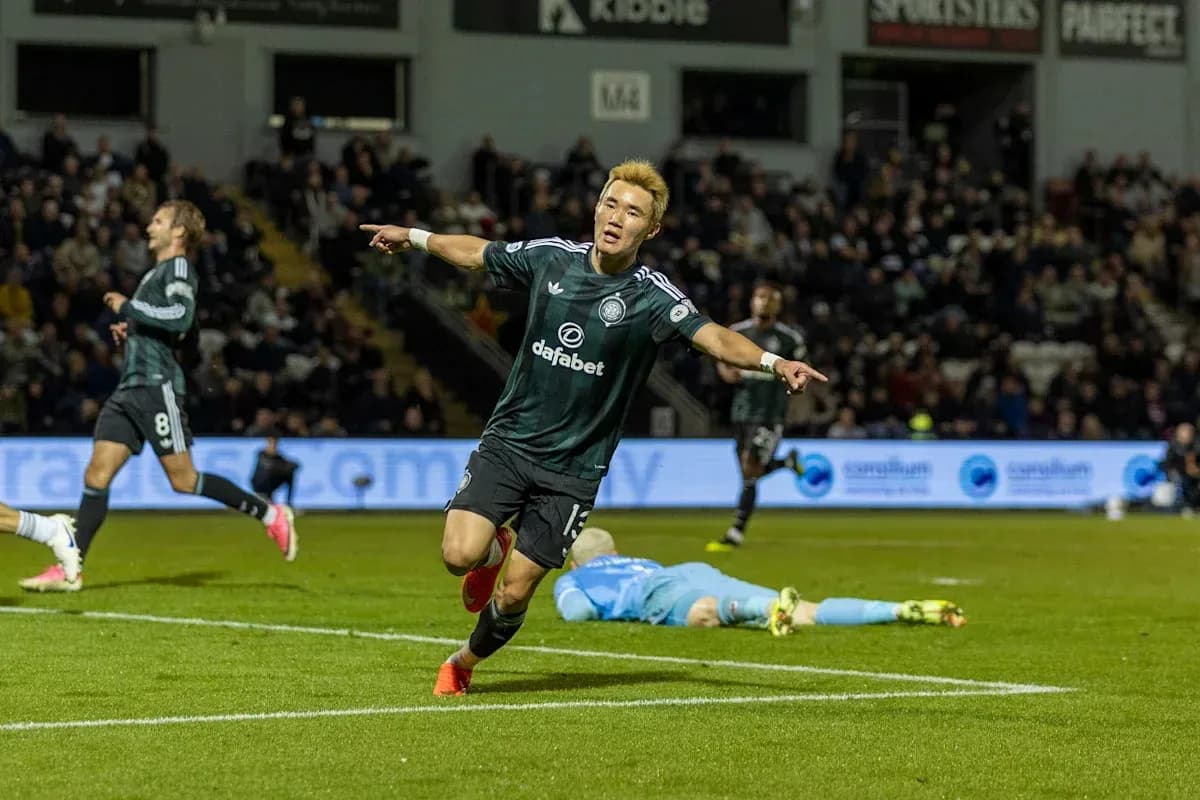 Player celebrating a goal with teammates in background Player celebrating a goal with teammates in background
