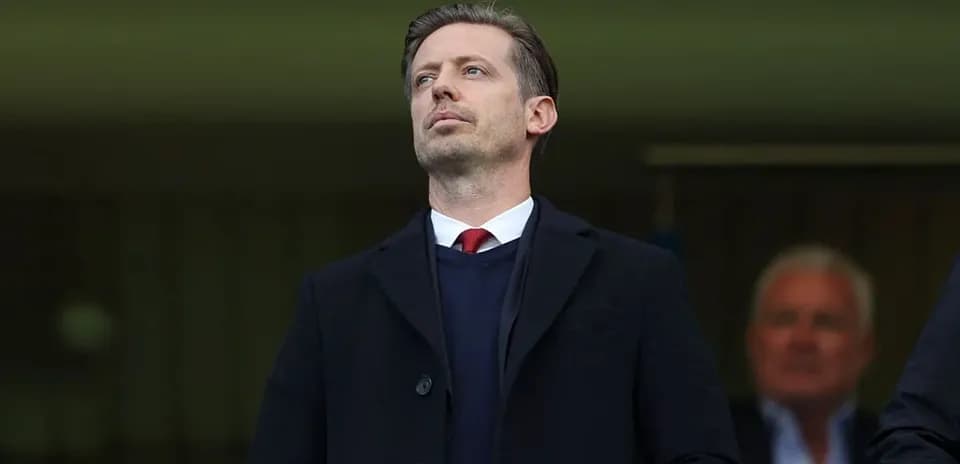 Man in a black coat observing an event