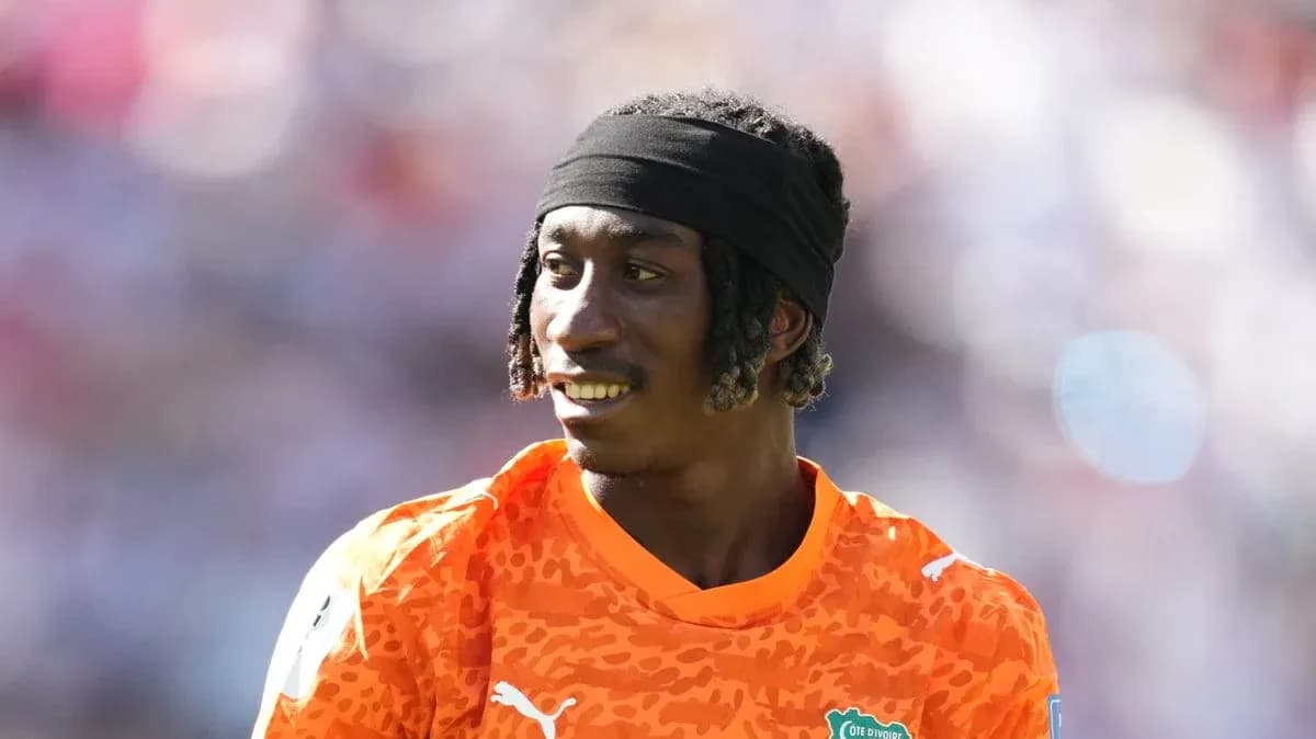 Goalkeeper in orange jersey during match warm-up