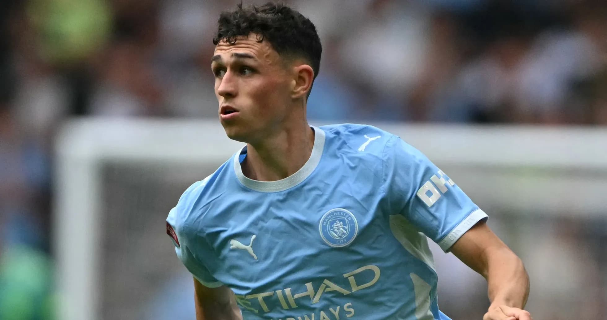 Player in light blue Manchester City kit running