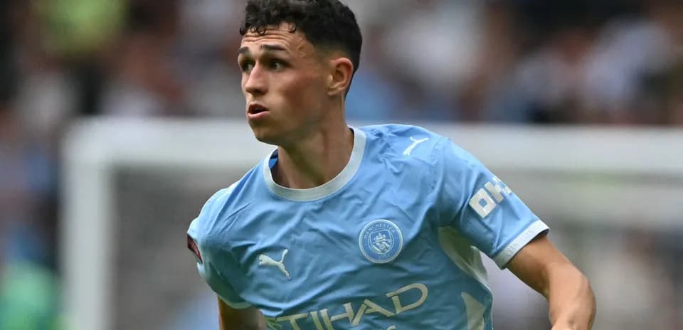 Player in light blue Manchester City kit running