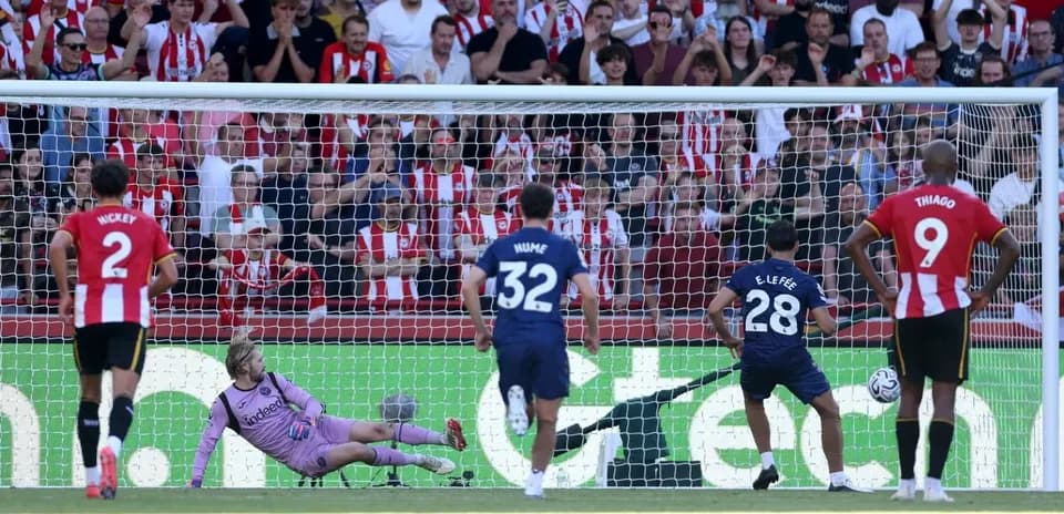Player taking penalty kick with goalkeeper diving
