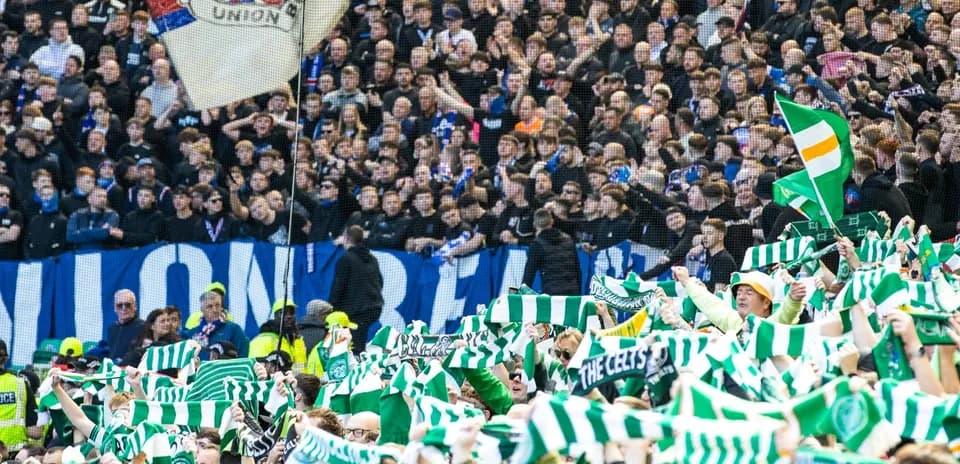 Celtic fans waving scarves during a match