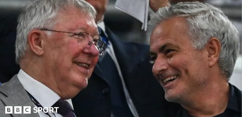 Two men smiling and conversing in a crowd