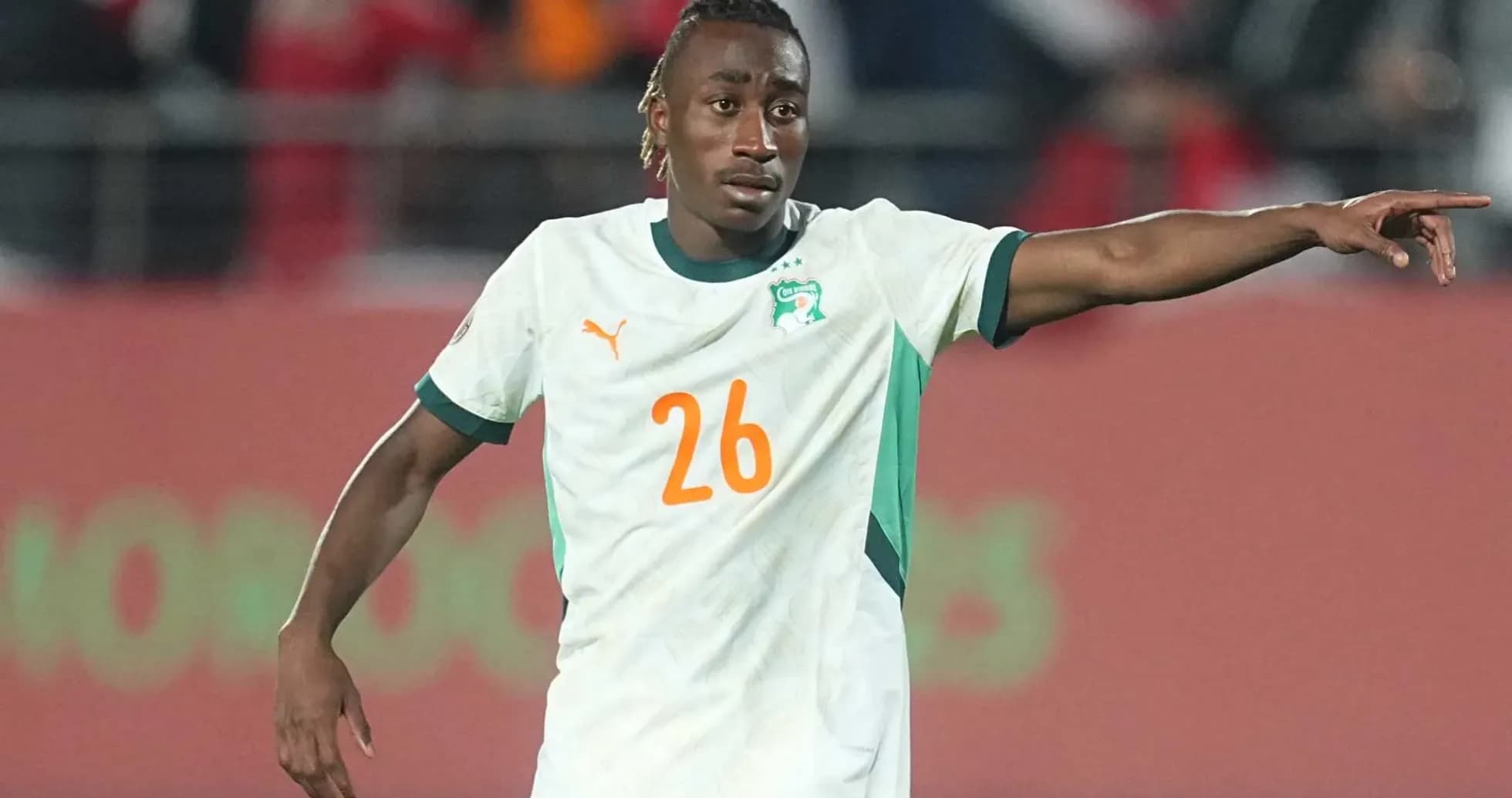 Player wearing Ivory Coast jersey directing teammates on field