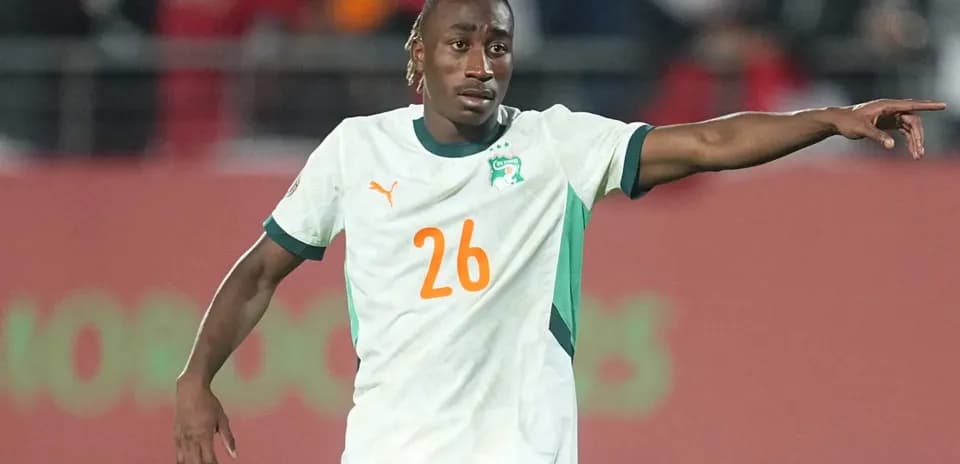 Player wearing Ivory Coast jersey directing teammates on field