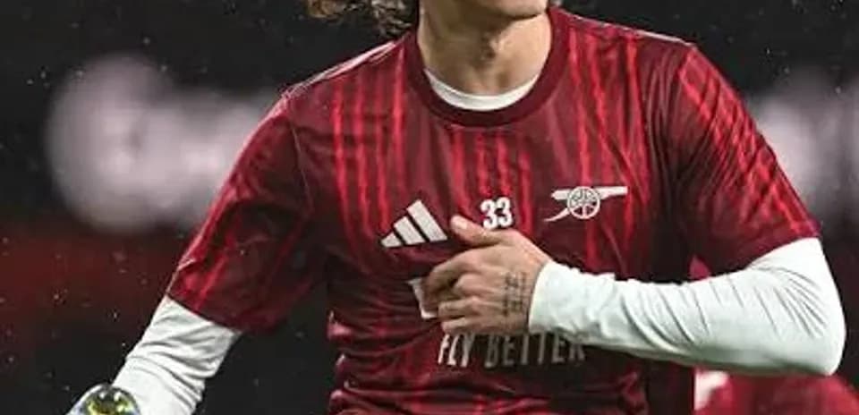 Player stretching during warm-up in red kit