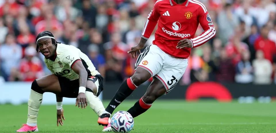 Manchester United player dribbling past opposing player