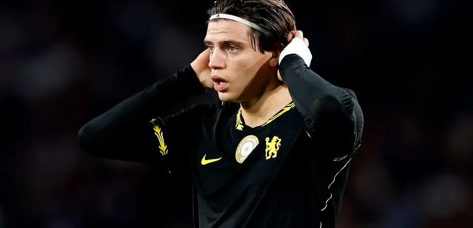Player in black jersey holding head during match