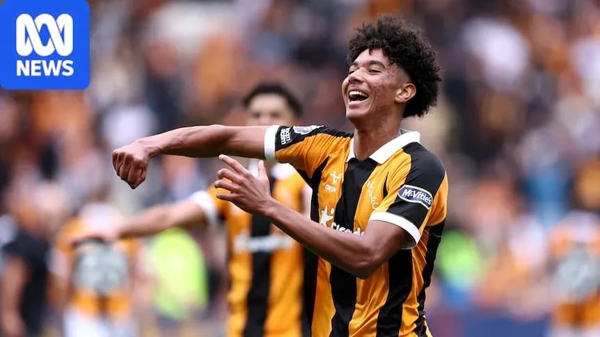 Player celebrating a goal with teammates in stadium