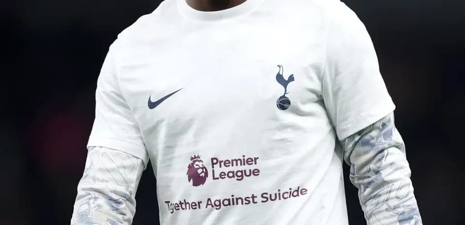 Player walking on pitch in Tottenham warm-up shirt
