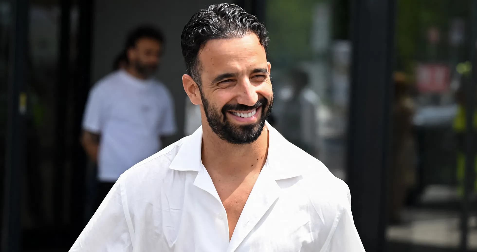 Man smiling in a white shirt outdoors