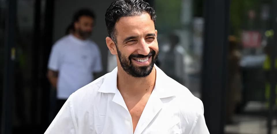 Man smiling in a white shirt outdoors