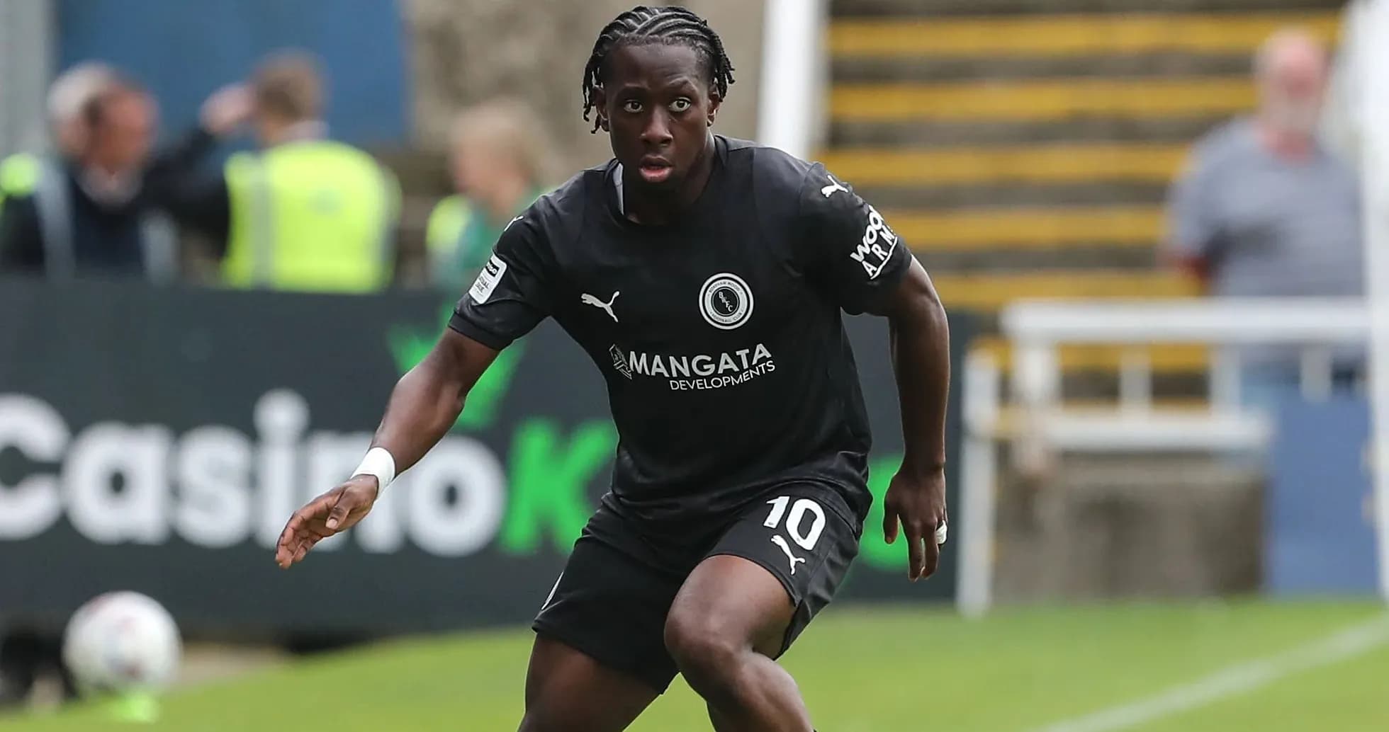 Player in black kit running on the field