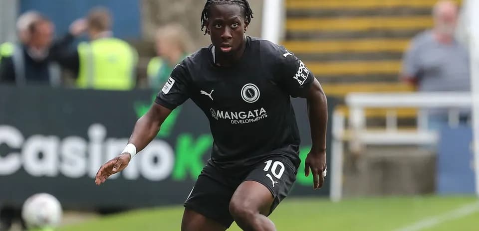 Player in black kit running on the field