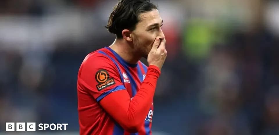 Player in red jersey holding face during match