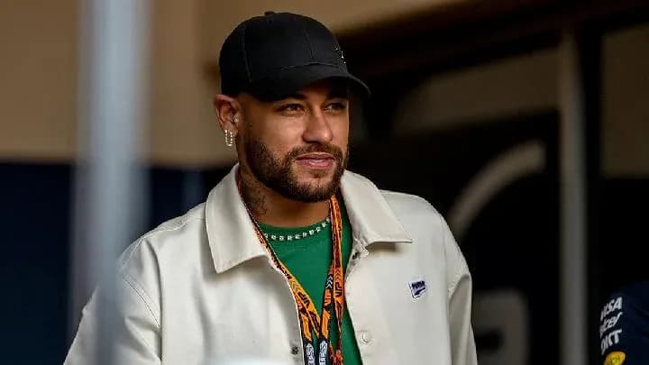 Neymar smiling while wearing a cap and jacket