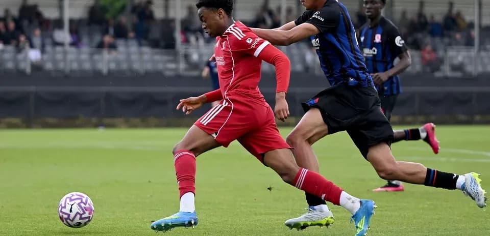 Player in red jersey evading opponent during match