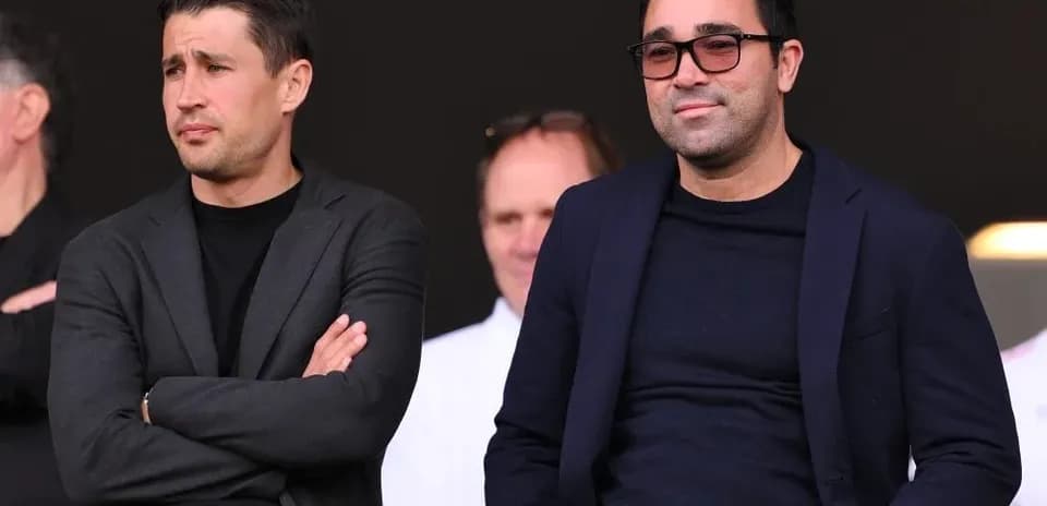 Two men seated in a sports venue box