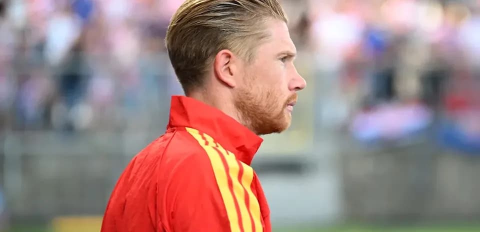 Player in red jacket looking at the field