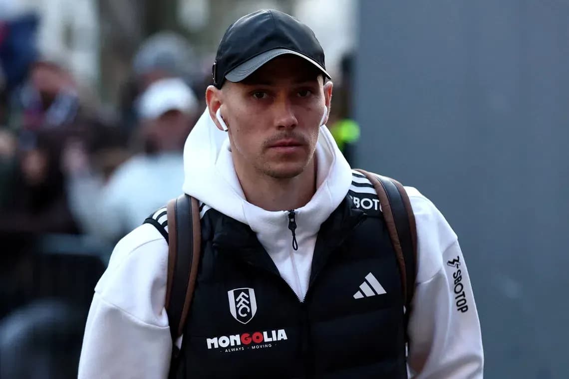 Player walking with headphones and backpack before match