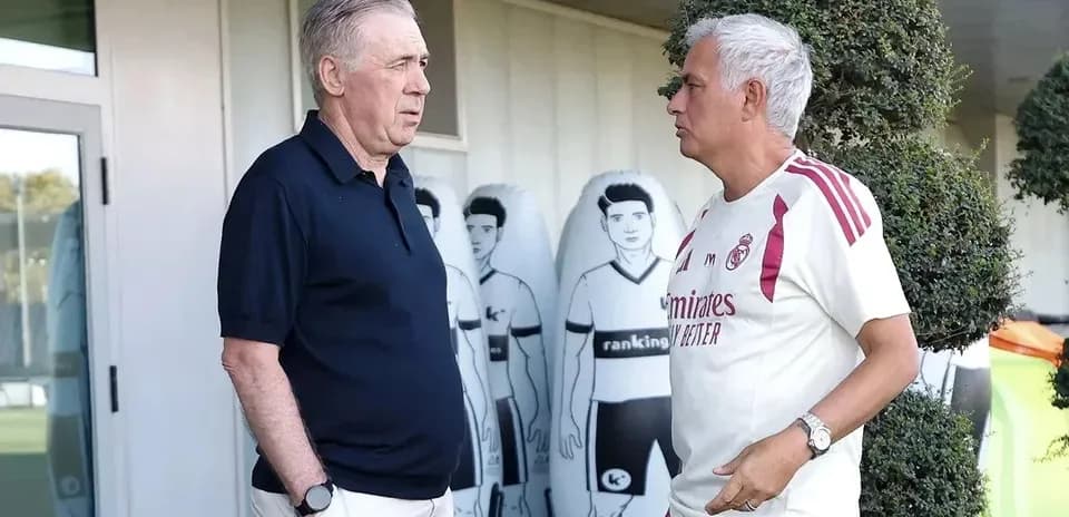 Two football managers conversing at training facility