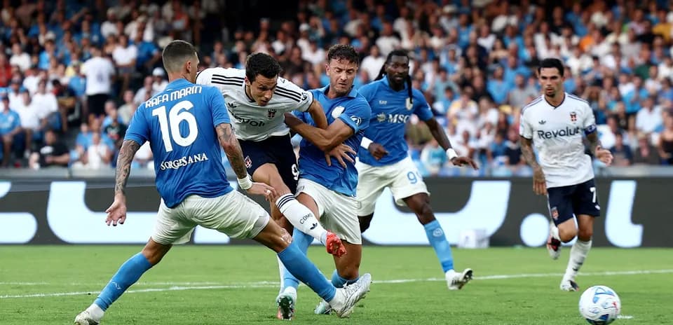 Napoli players challenging Como striker during match
